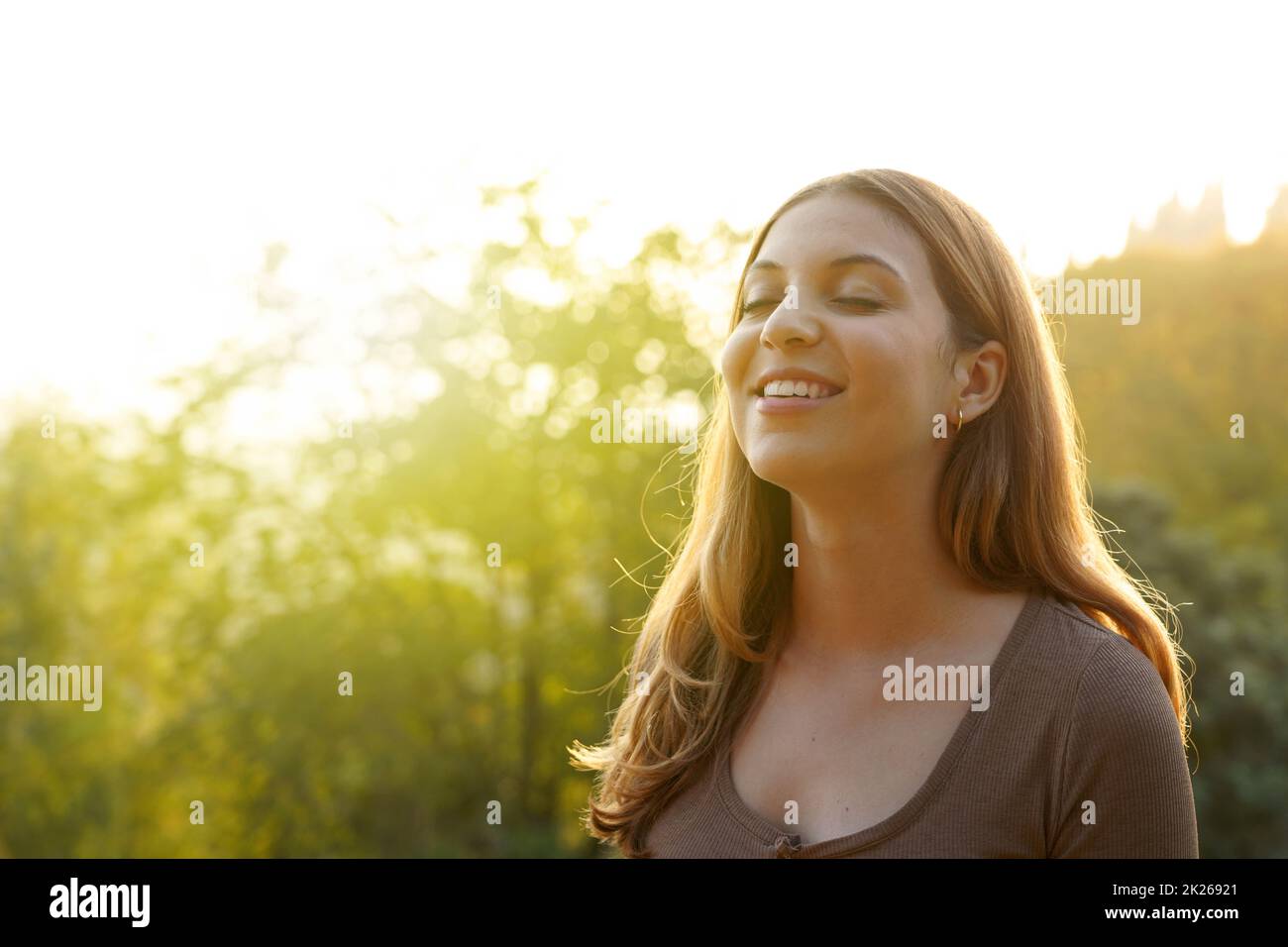 Belle femme respirant de l'air frais sur fond naturel.Copier l'espace. Banque D'Images