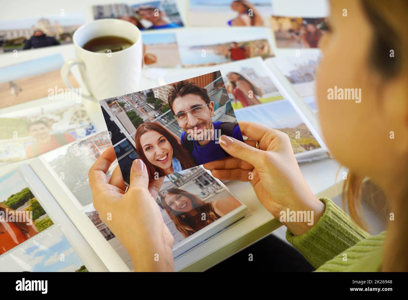 Jeune femme regardant des photos avec son ex-petit ami à la maison Banque D'Images