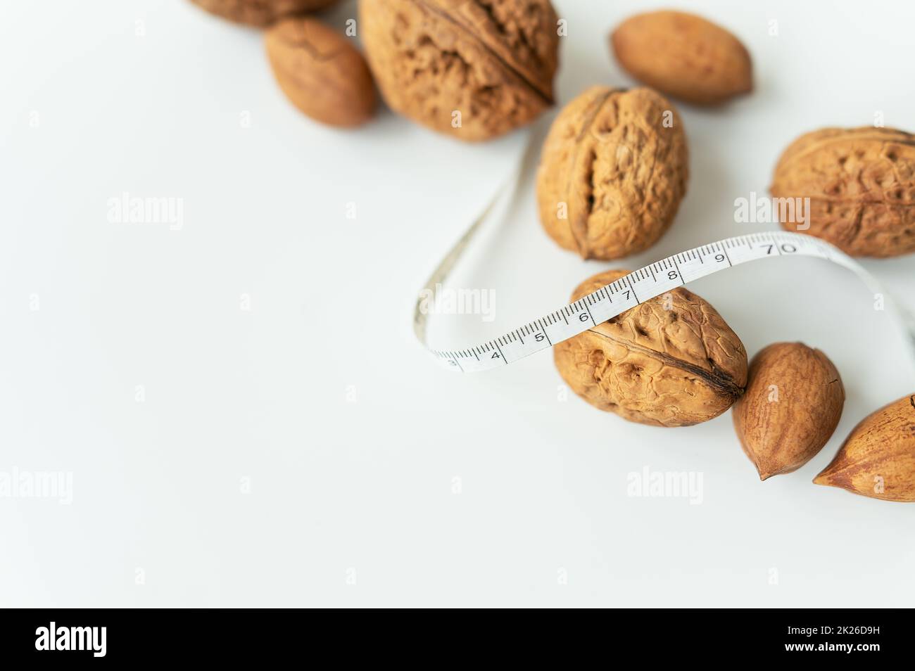 Beaux noyaux de noyer entier, noix entières en coquille sur une table blanche. Centimètre entre les noix, les noix à faible calorie. Mise au point sélective. Banque D'Images