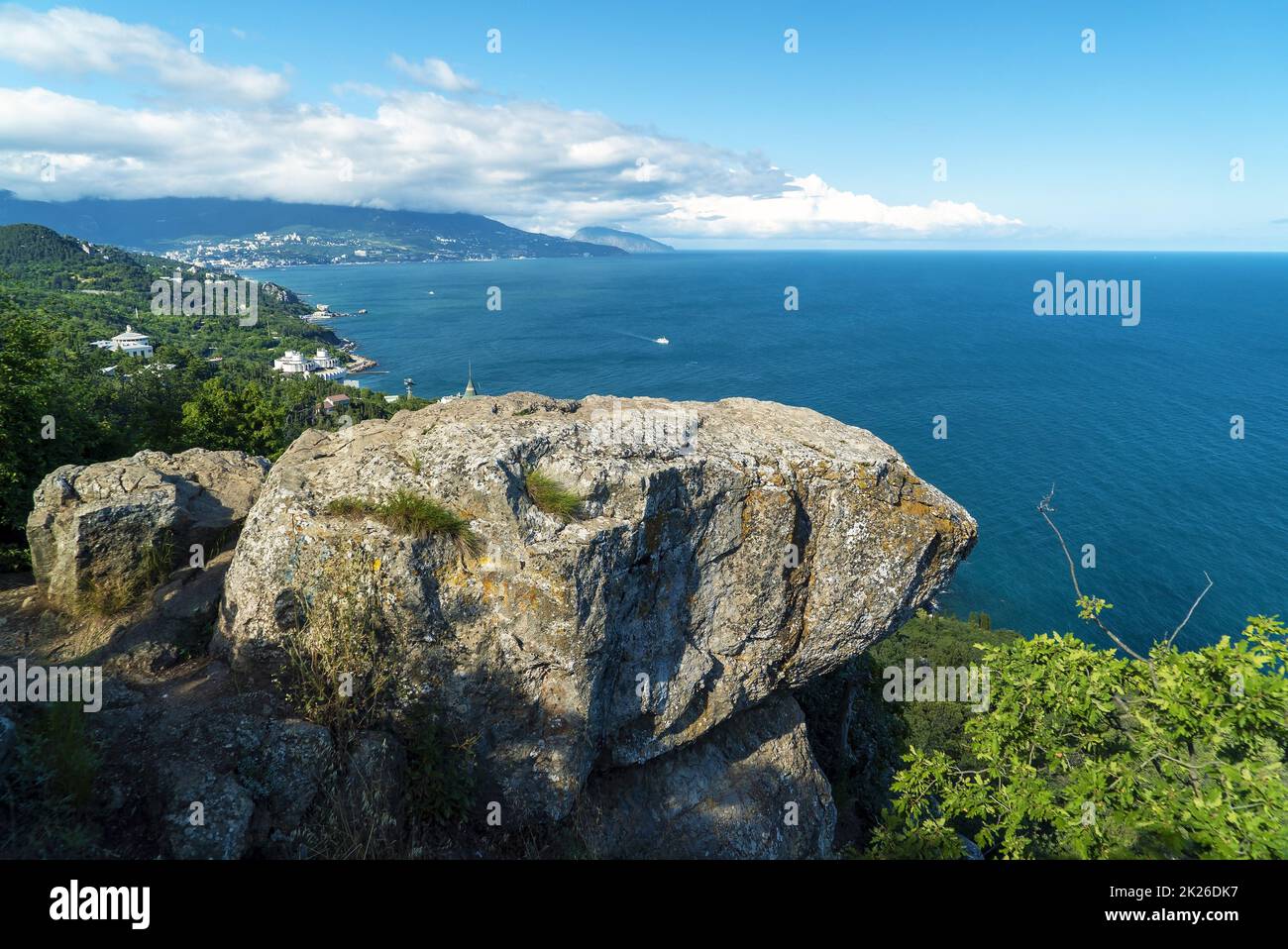 Vue sur la mer et Yalta depuis le chemin ensoleillé et une grande pierre surplombant. Crimée. Banque D'Images