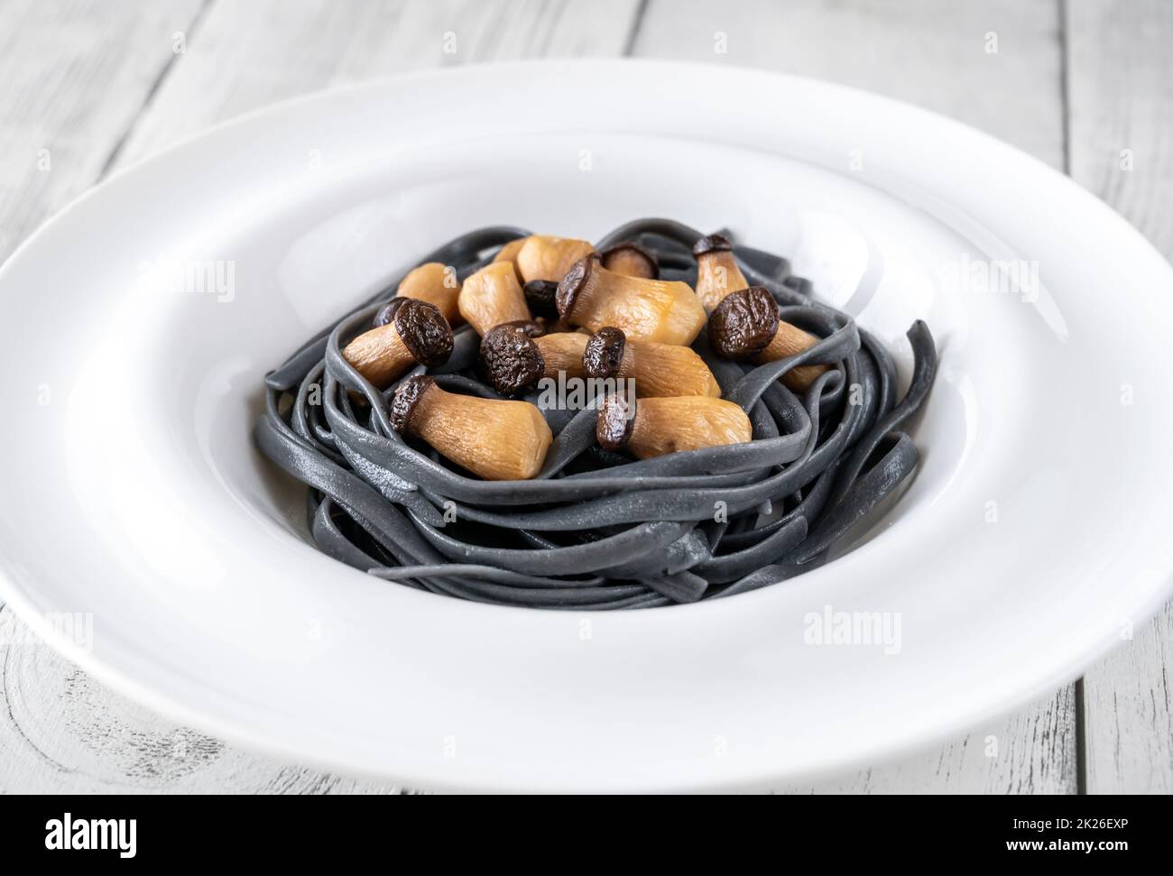 Pâtes noires avec de petits champignons Banque D'Images