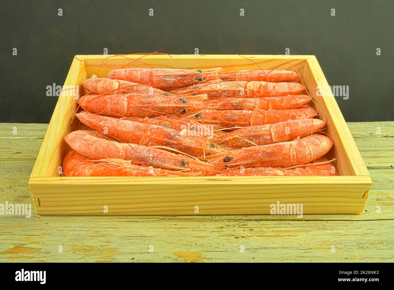 Crevettes cuites rouges sur fond noir et blanc dans une boîte en bois . Vue à angle bas et espace de copie. Alimentation marine Banque D'Images