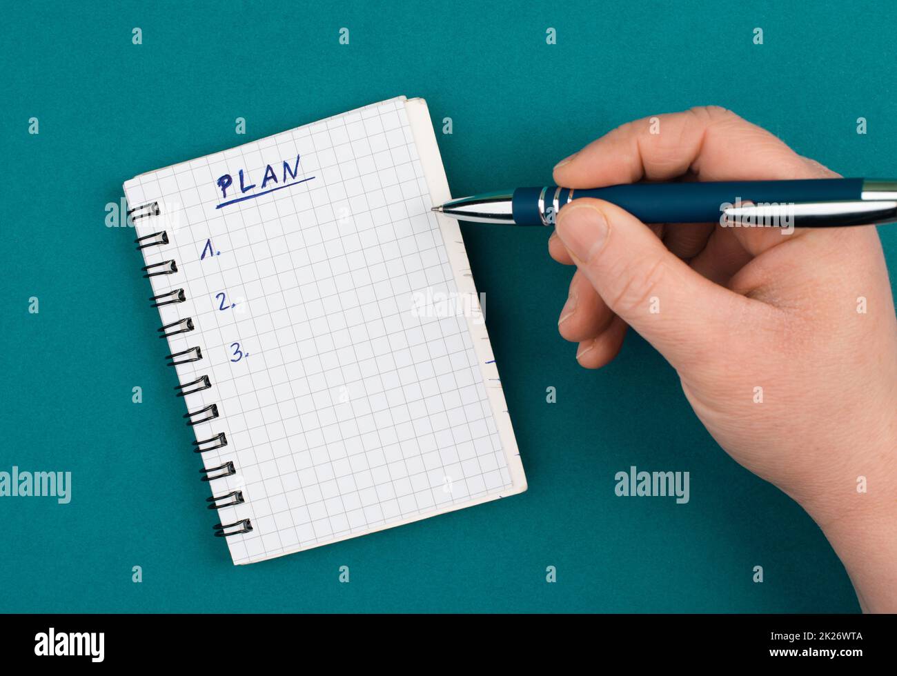 Bloc-notes vide avec un stylo sur un fond de couleur essence, le mot plan se trouve en haut de la page, la planification de nouveaux objectifs, la liste des tâches Banque D'Images