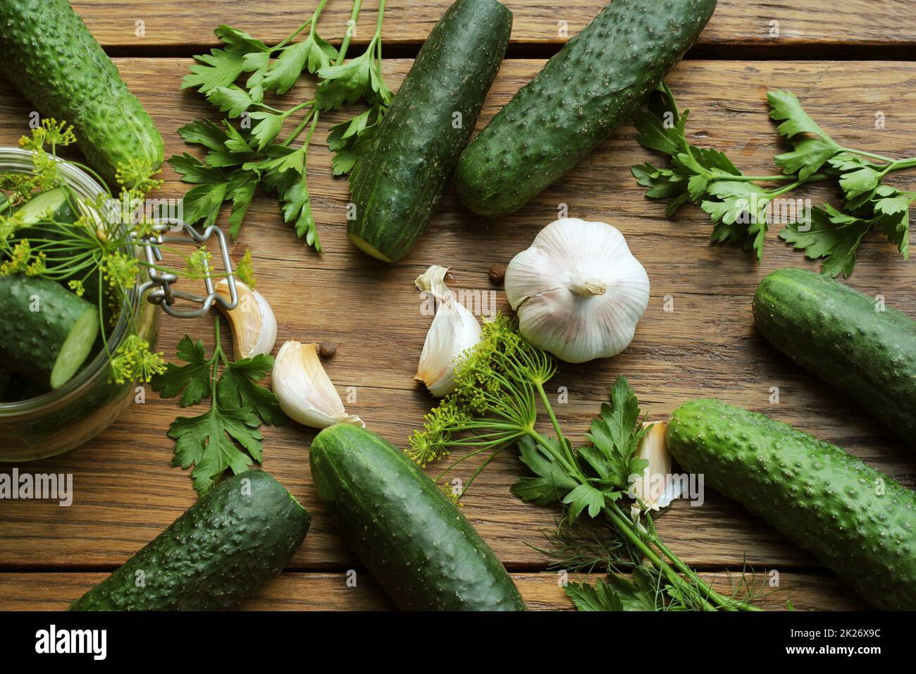 Pot en verre de concombres marinés aux herbes sur fond de bois rustique. Aliments marinés et en conserve. Vue de dessus Banque D'Images