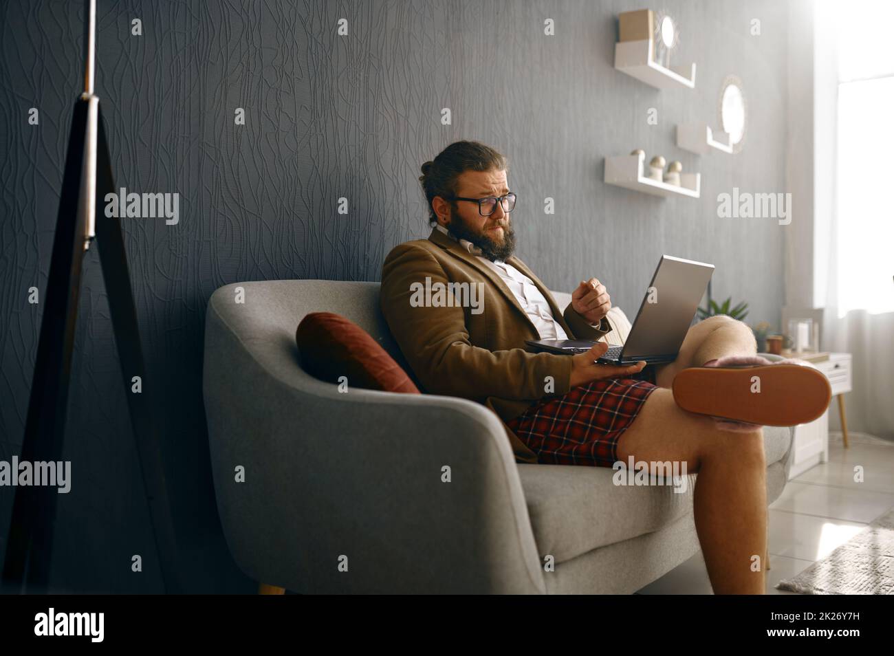 Homme d'affaires communiquant via un ordinateur portable à partir d'un bureau à domicile Banque D'Images