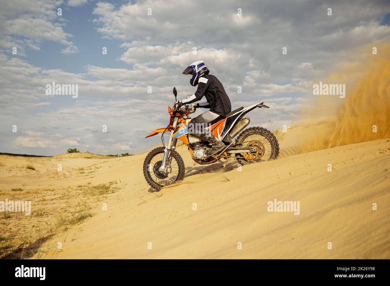 Conducteur de motocross professionnel glissant sur une colline de sable Banque D'Images