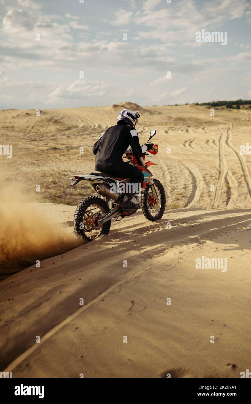 Conducteur de motocross professionnel conduisant sur une dune de sable Banque D'Images