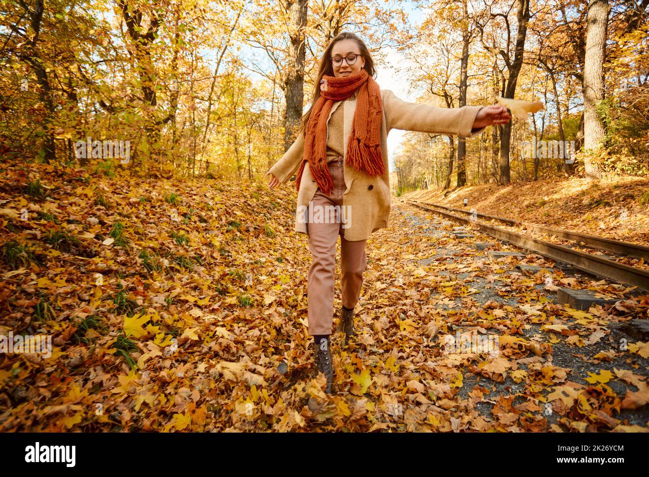 Femme dansant dans la nature parmi les feuilles d'automne Banque D'Images