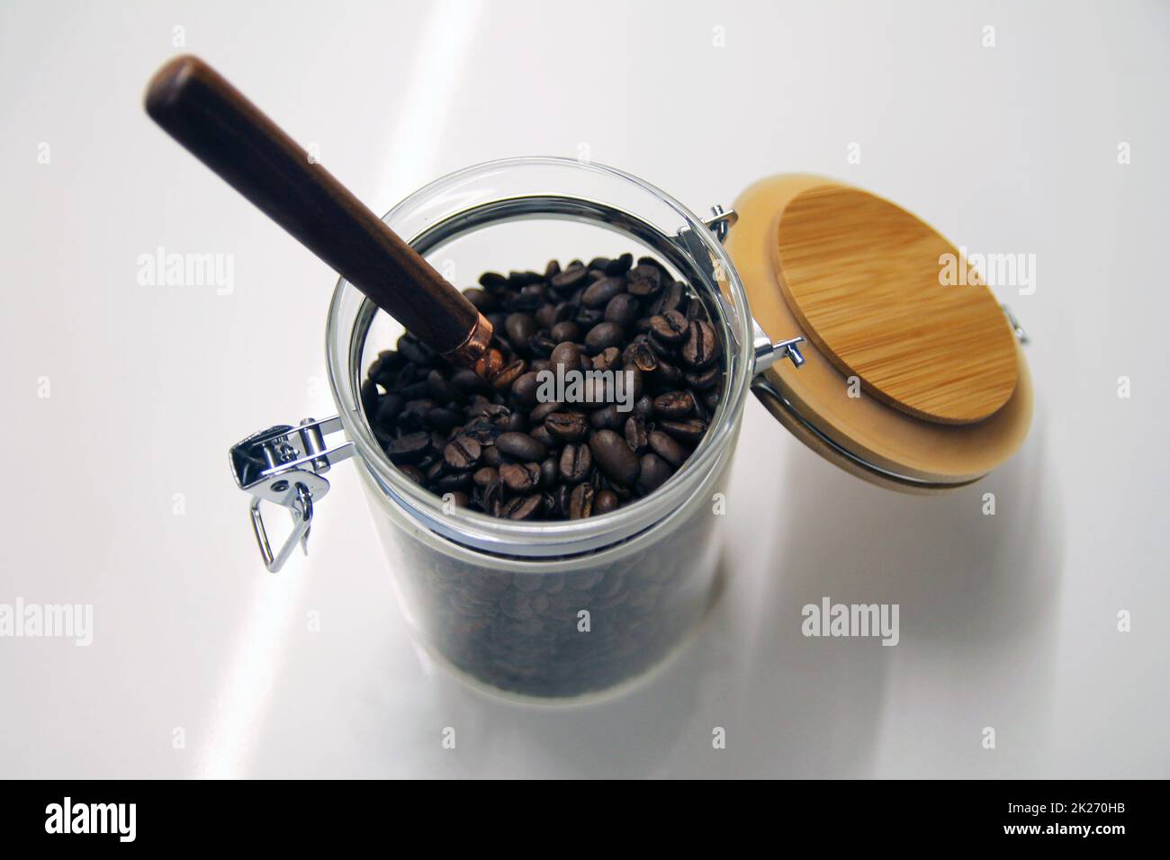 Gros plan d'un pot isolé en verre et en bois avec une cuillère en cuivre et en bois Banque D'Images