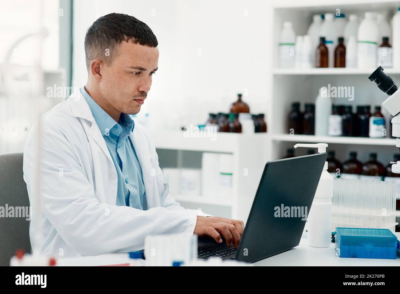 Restez calme, le remède est à venir.Photo d'un jeune scientifique utilisant un ordinateur portable tout en travaillant dans un laboratoire. Banque D'Images