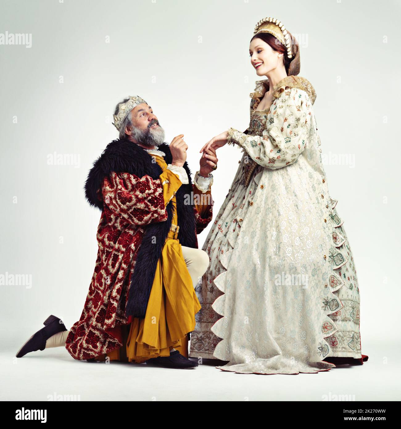 Rejoignez-moi sur le trône.Studio photo d'un roi proposant à une dame royale. Banque D'Images