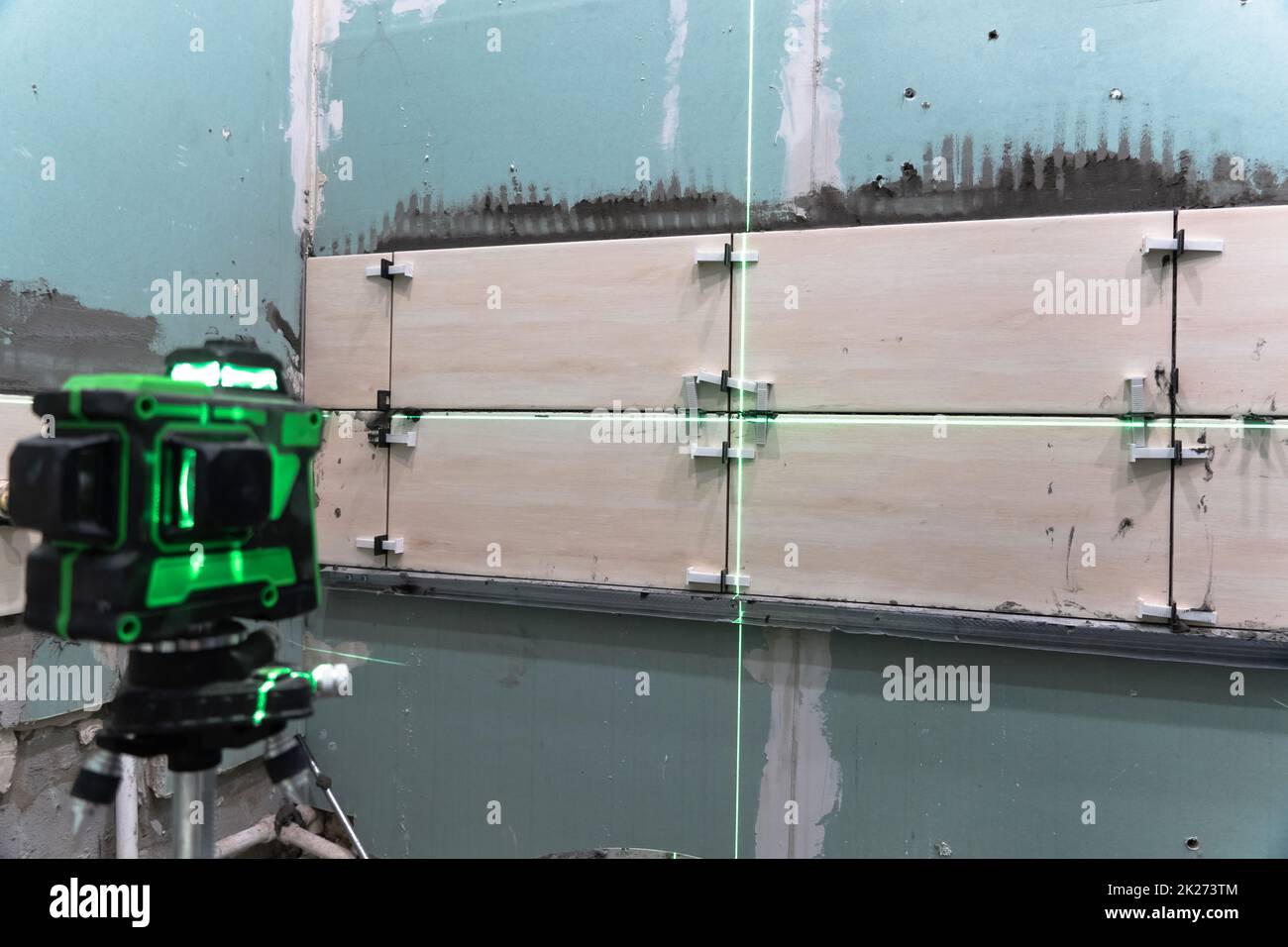 Construction et réparation de murs dans un nouveau bâtiment.pose de carreaux de mur à l'aide d'un niveau de construction et d'un niveau laser. Rénovation dans la maison. Effectuer des calculs et des mesures à l'aide d'un laser Banque D'Images