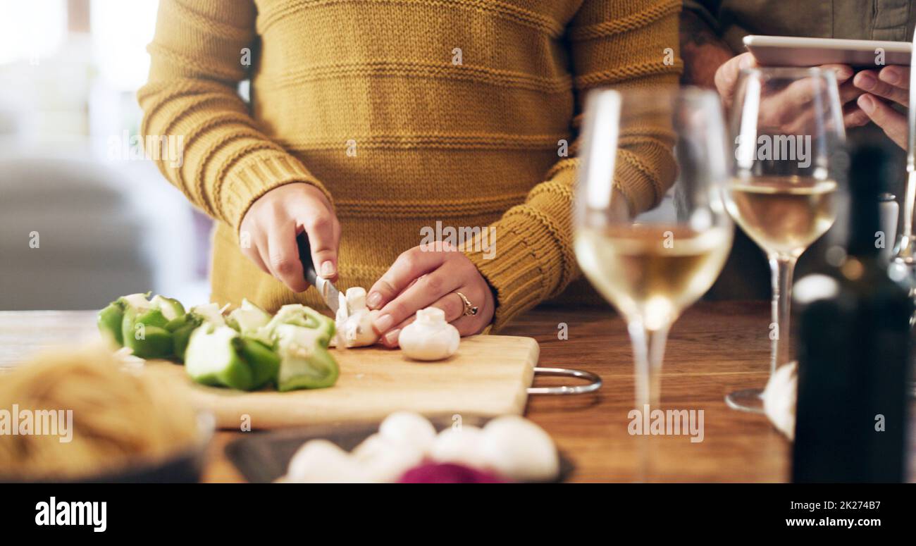 Une vie saine commence à la maison.Prise de vue rognée d'un couple à l'aide d'une tablette numérique tout en préparant un repas à la maison. Banque D'Images