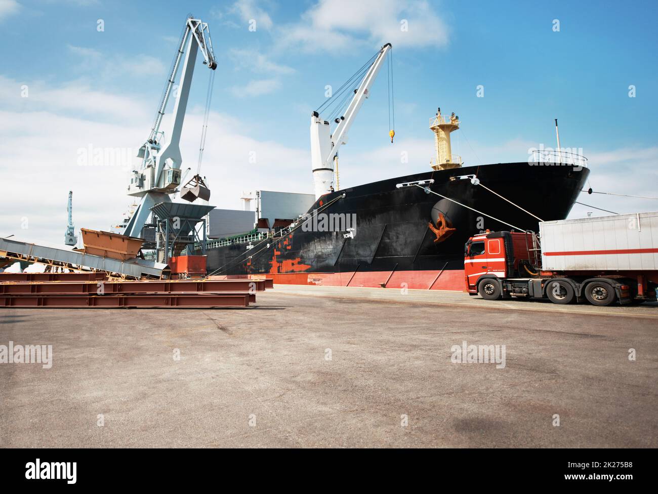 L'importation et l'exportation ne cessent jamais.Une photo d'un port avec des navires ancrés et un camion fixe. Banque D'Images