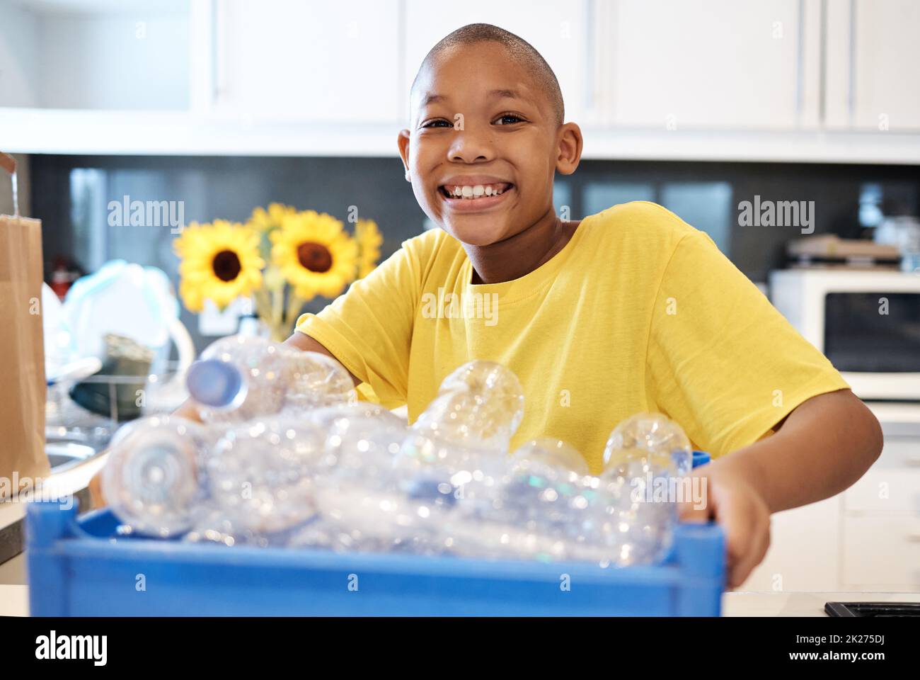 Assurer l'avenir des terres par le recyclage.Photo d'un jeune garçon se préparer à recycler quelques bouteilles à la maison. Banque D'Images