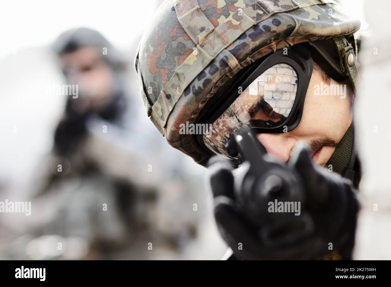 Tireur d'aigle.Gros plan d'un sniper avec un pistolet pointé vers la caméra et le soldat en arrière-plan avec l'espace de copie. Banque D'Images