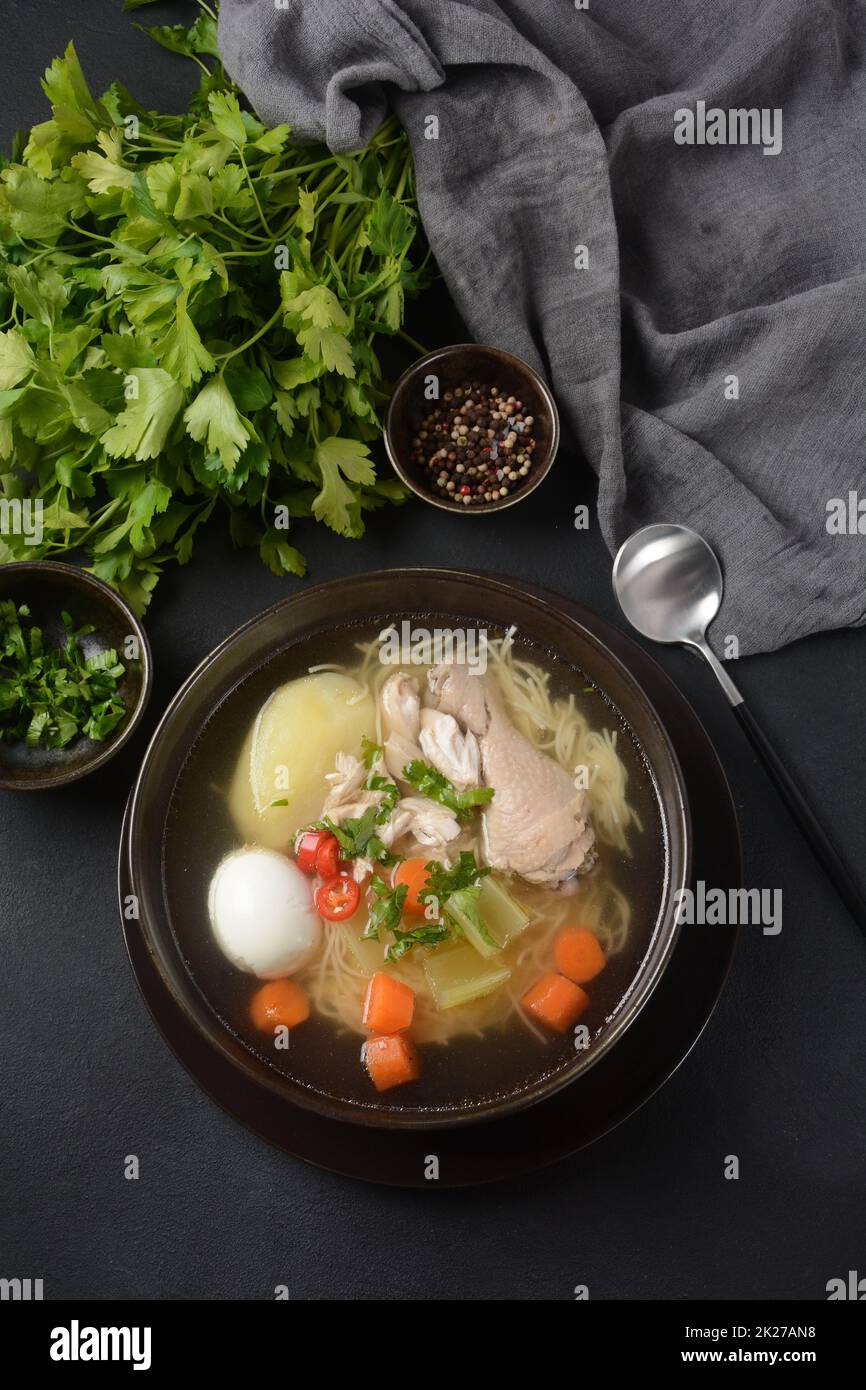 Soupe de nouilles de poulet au Caldo de Gallina avec œufs durs et herbes.La soupe péruvienne classique de nouilles de poulet. Banque D'Images