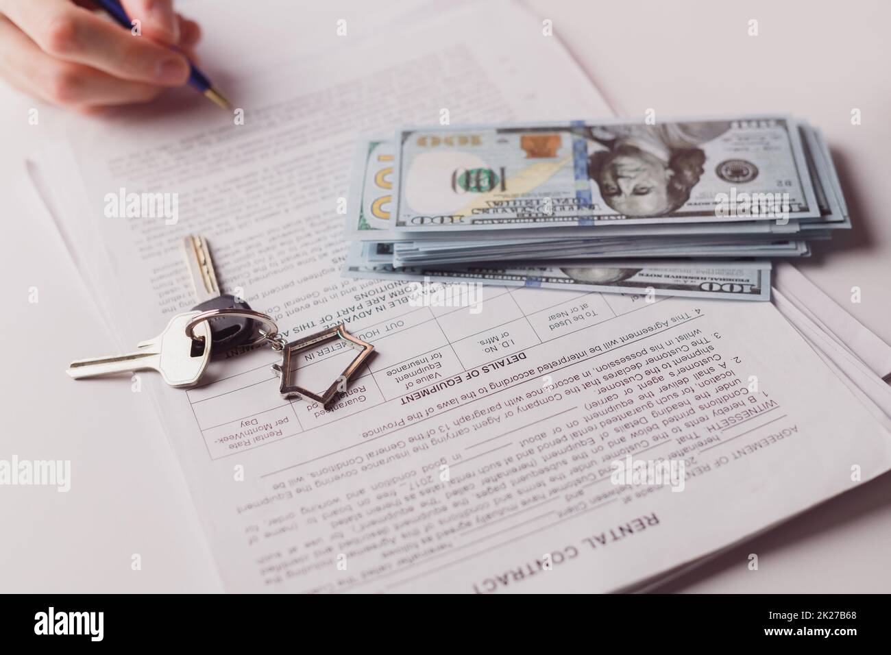 Homme signant un contrat immobilier, faisant une affaire avec de l'argent comptant et des clés à la maison. Achat ou location. Banque D'Images