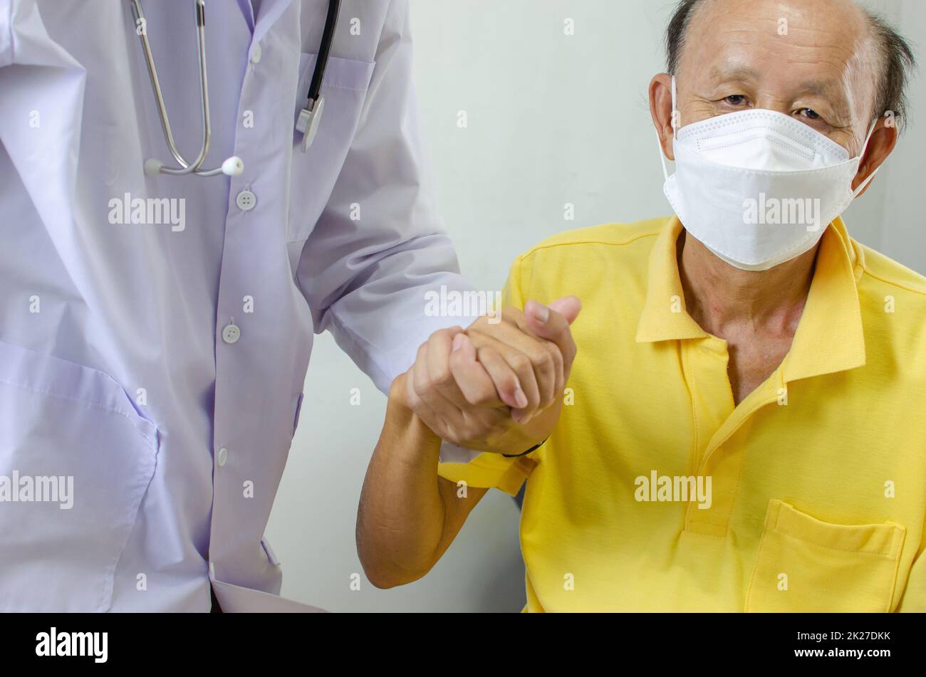 le médecin tient la main d'un homme âgé pour l'encourager. Banque D'Images