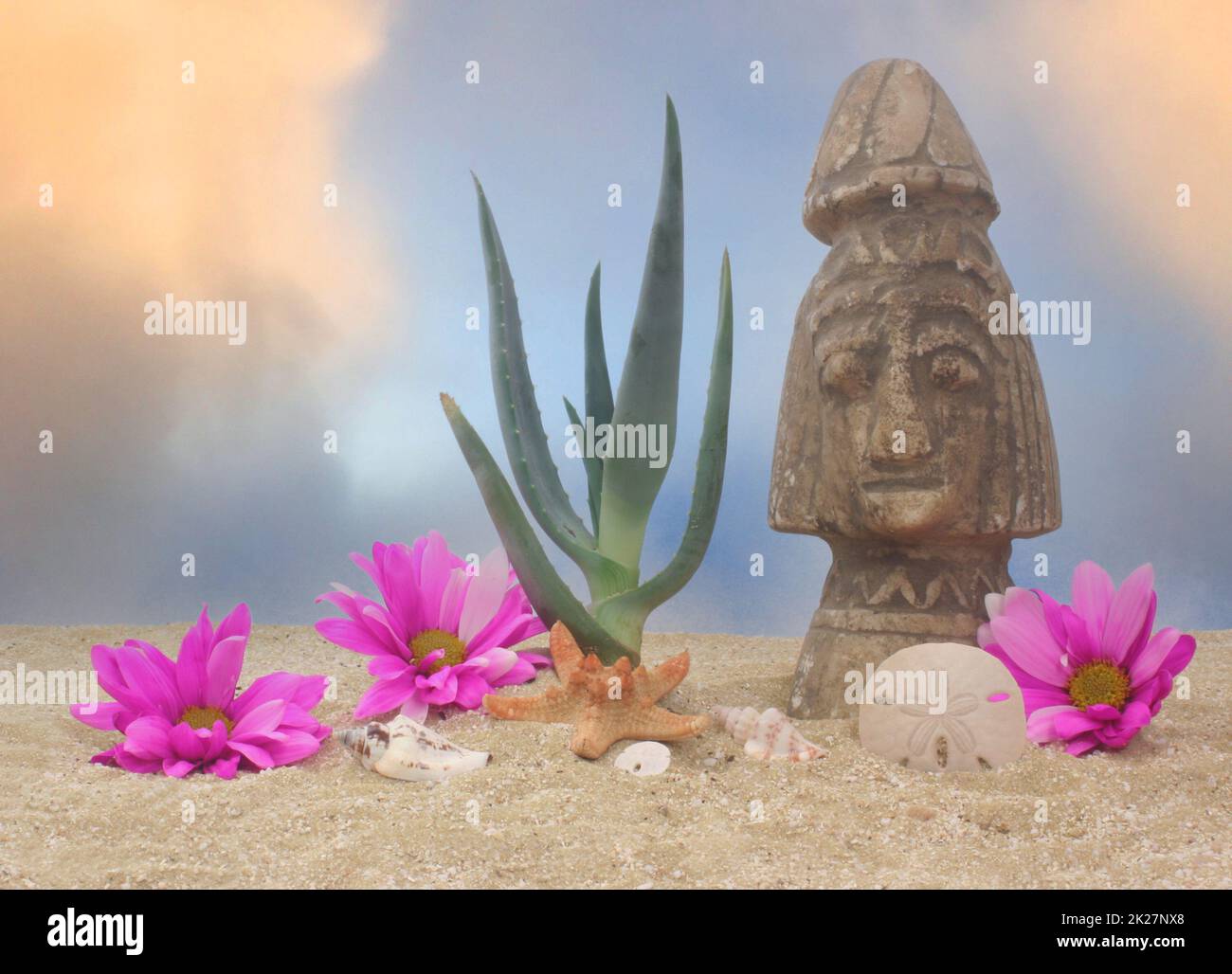 Plante d'aloès et statue sur fond de ciel bleu et de sable Banque D'Images