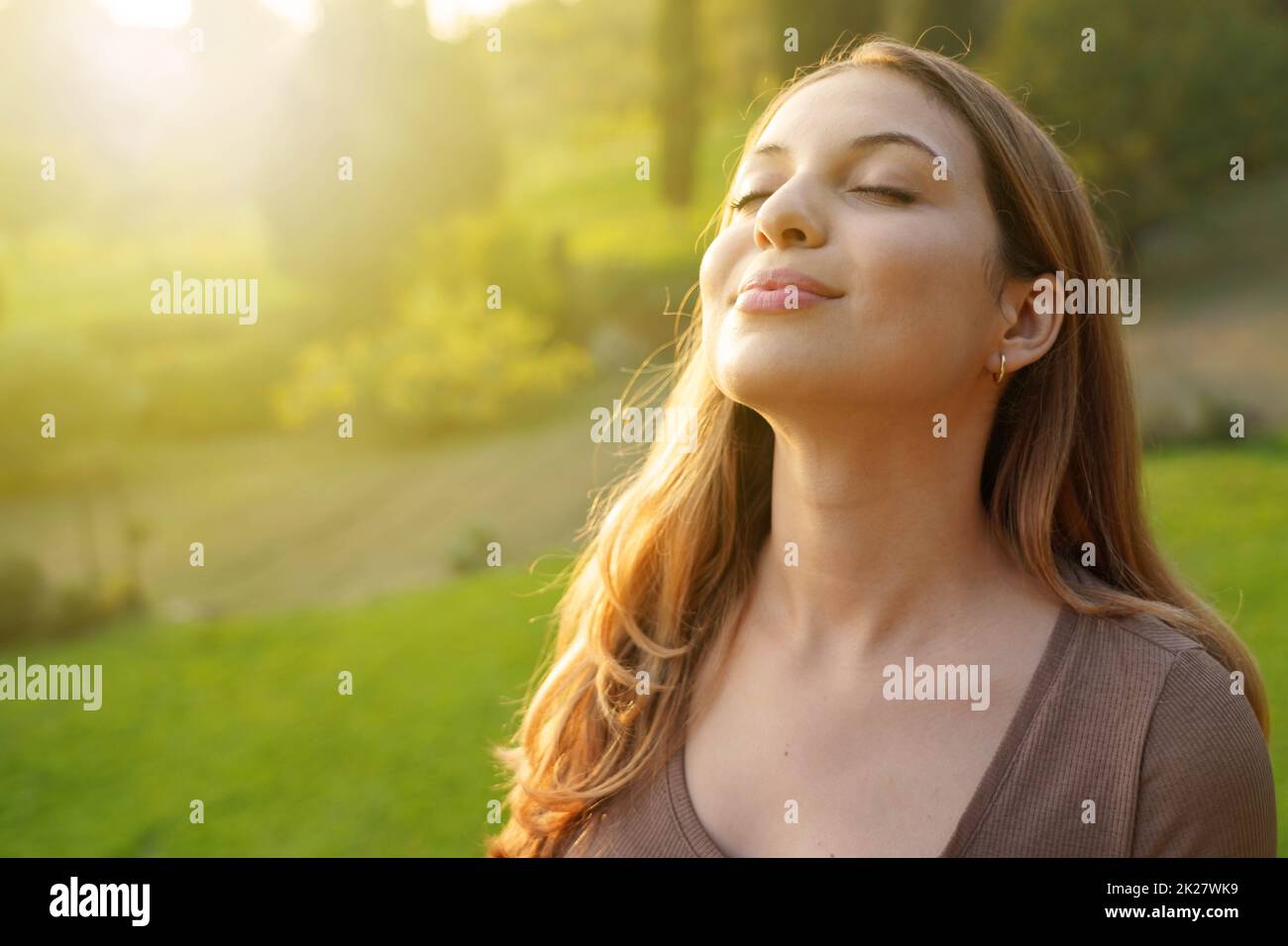 Femme en gros plan au coucher du soleil en respirant de l'air frais Banque D'Images