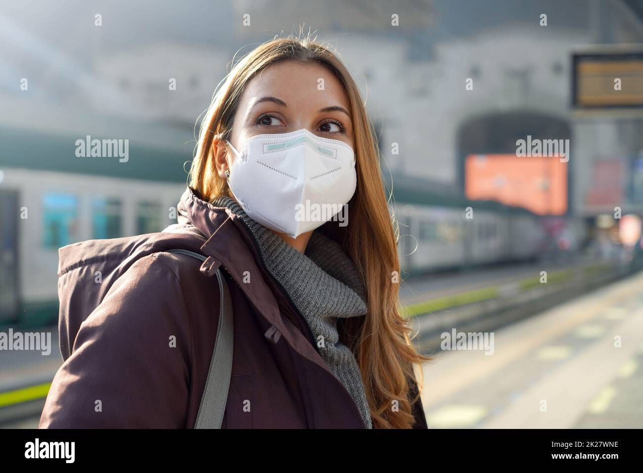 Portrait d'une femme décontractée en train d'attente avec KN95 FFP2 masques de protection à la gare l'hiver Banque D'Images