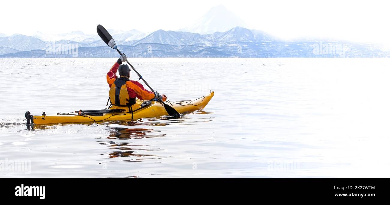 Kayakiste sur un bateau dans la mer calme sur la péninsule de Kamchatka Banque D'Images