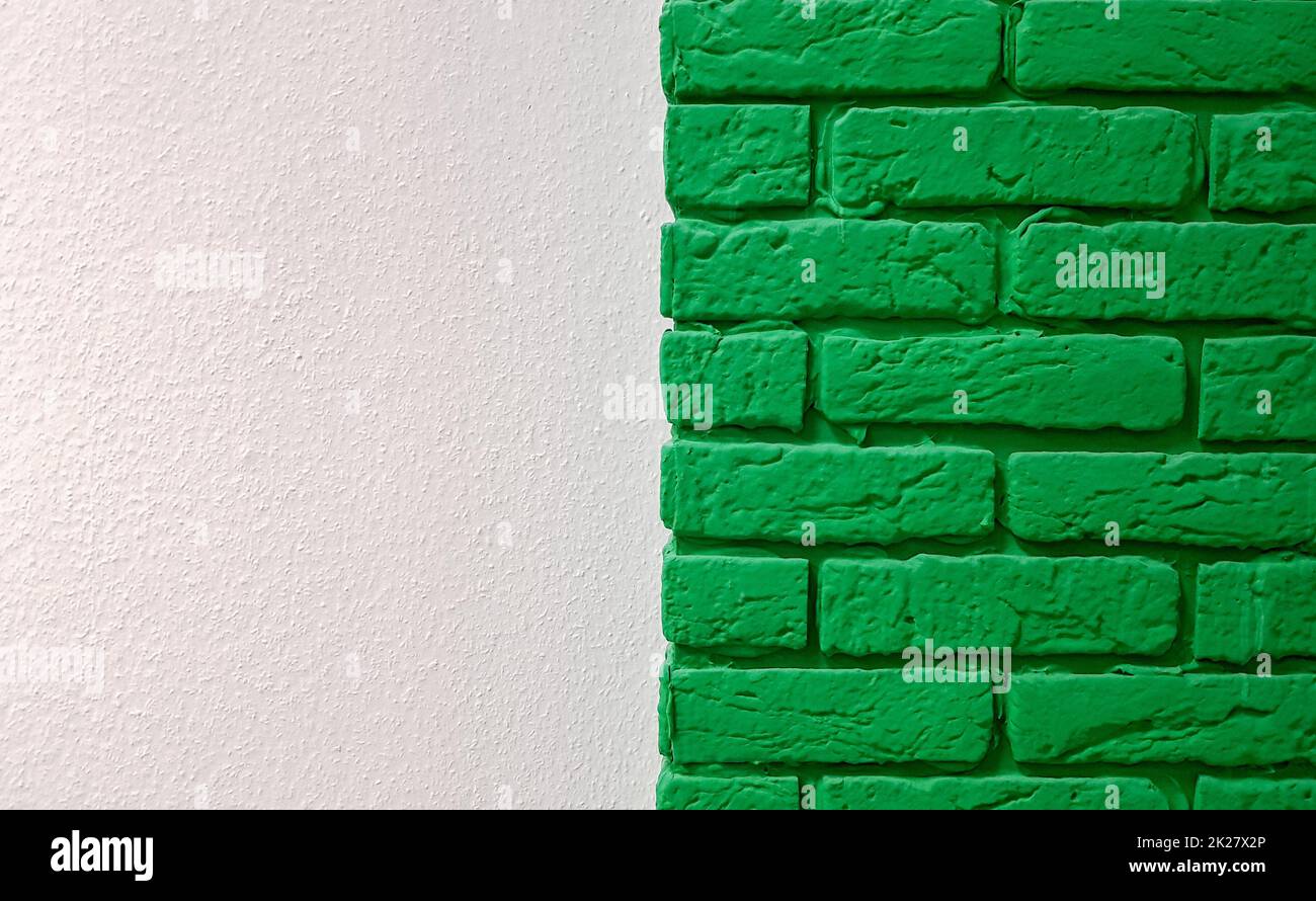 Nouveau mur moderne rose plat avec une colonne décorative en brique peinte en vert. Arrière-plan moderne abstrait texture tendance. Espace de copie espace vide pour votre texte et votre publicité. Banque D'Images