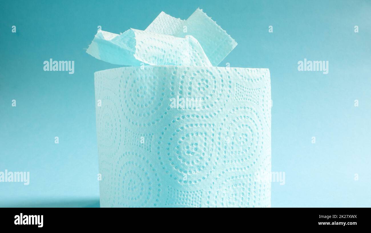 Rouleau bleu de papier toilette moderne sur fond bleu. Un produit en papier sur un manchon en carton, utilisé à des fins sanitaires à partir de cellulose avec des découpes pour faciliter le déchirement. Dessin en relief Banque D'Images