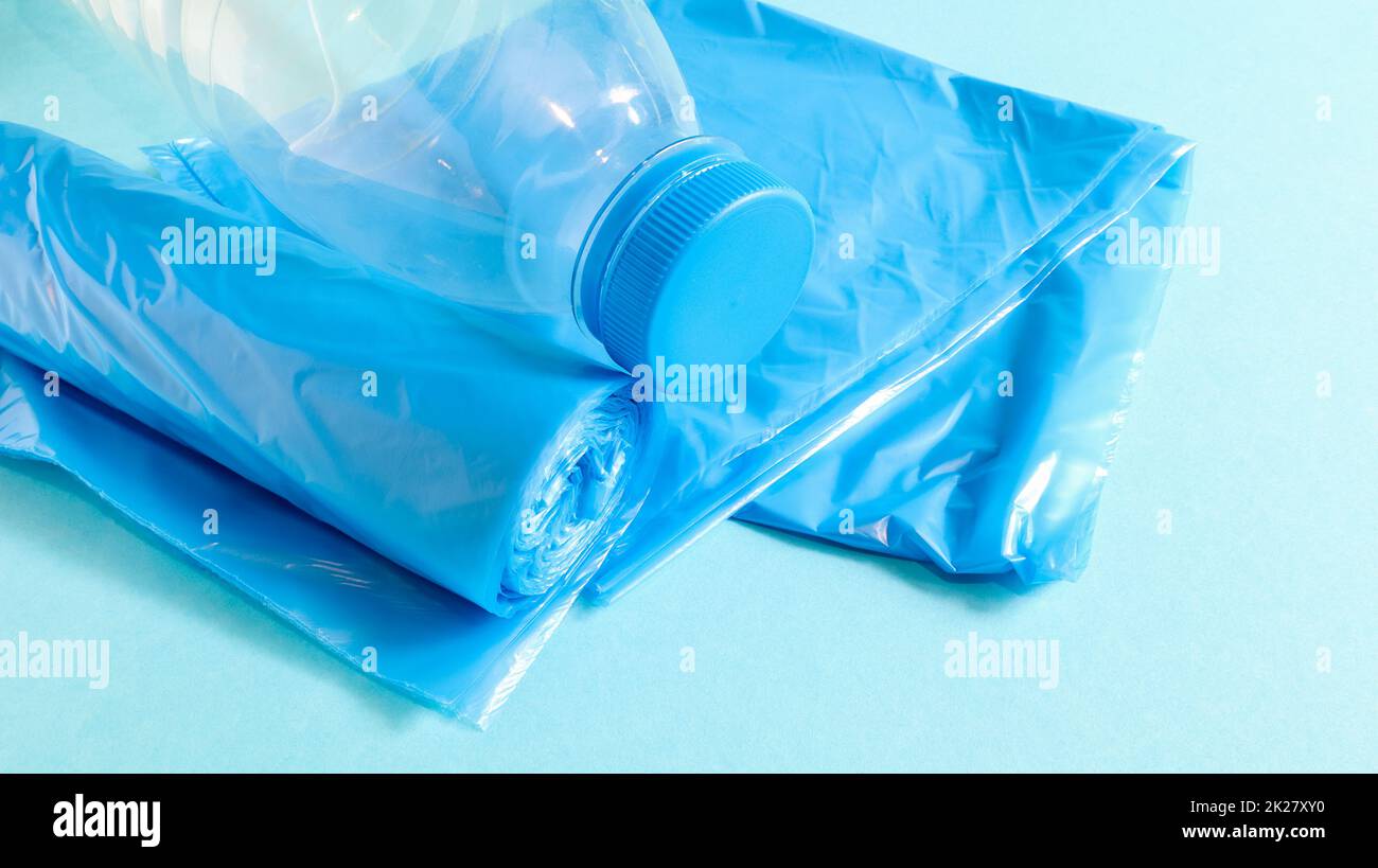 Un rouleau de sacs poubelle en plastique bleu sur fond bleu. Sacs qui sont conçus pour accueillir les ordures dans eux et utilisés à la maison et placés dans divers conteneurs à ordures. Copier l'espace Banque D'Images