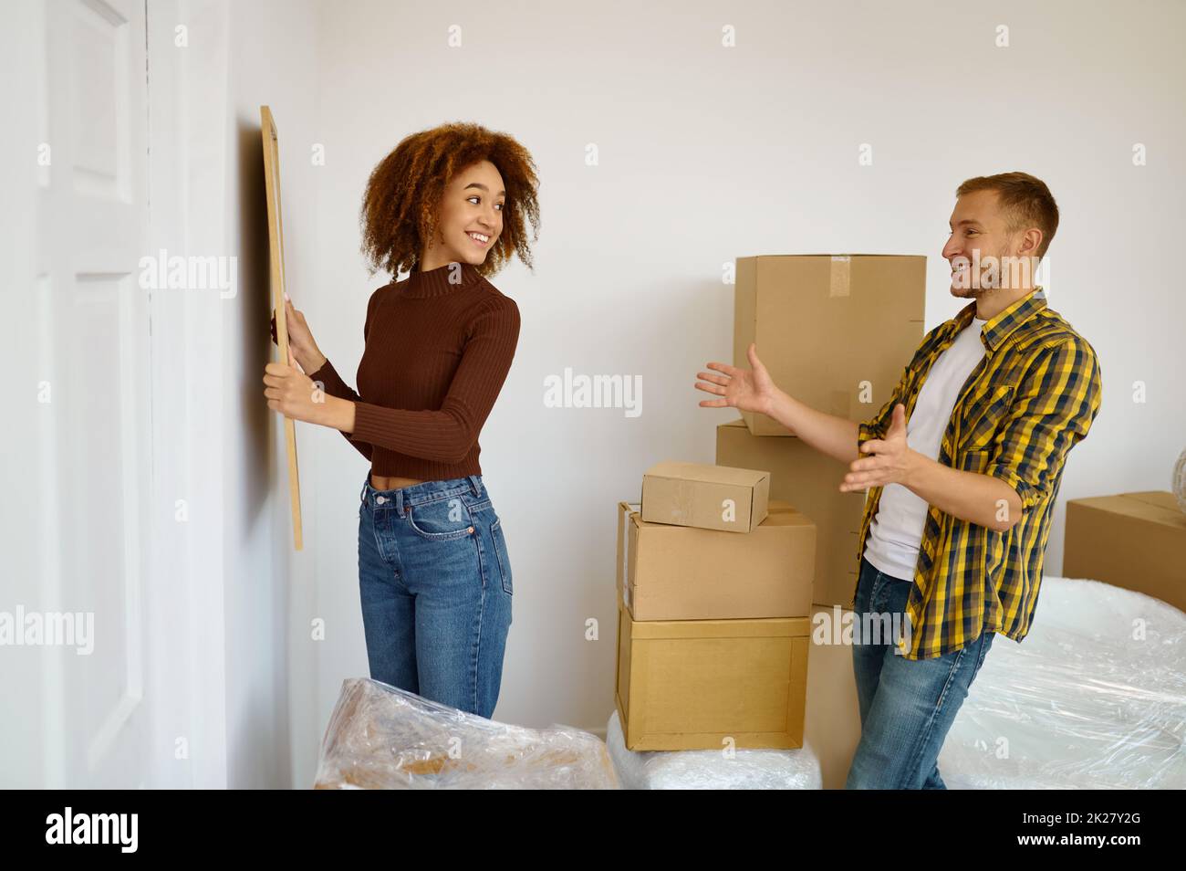 Femme accrochant l'image au mur Banque D'Images