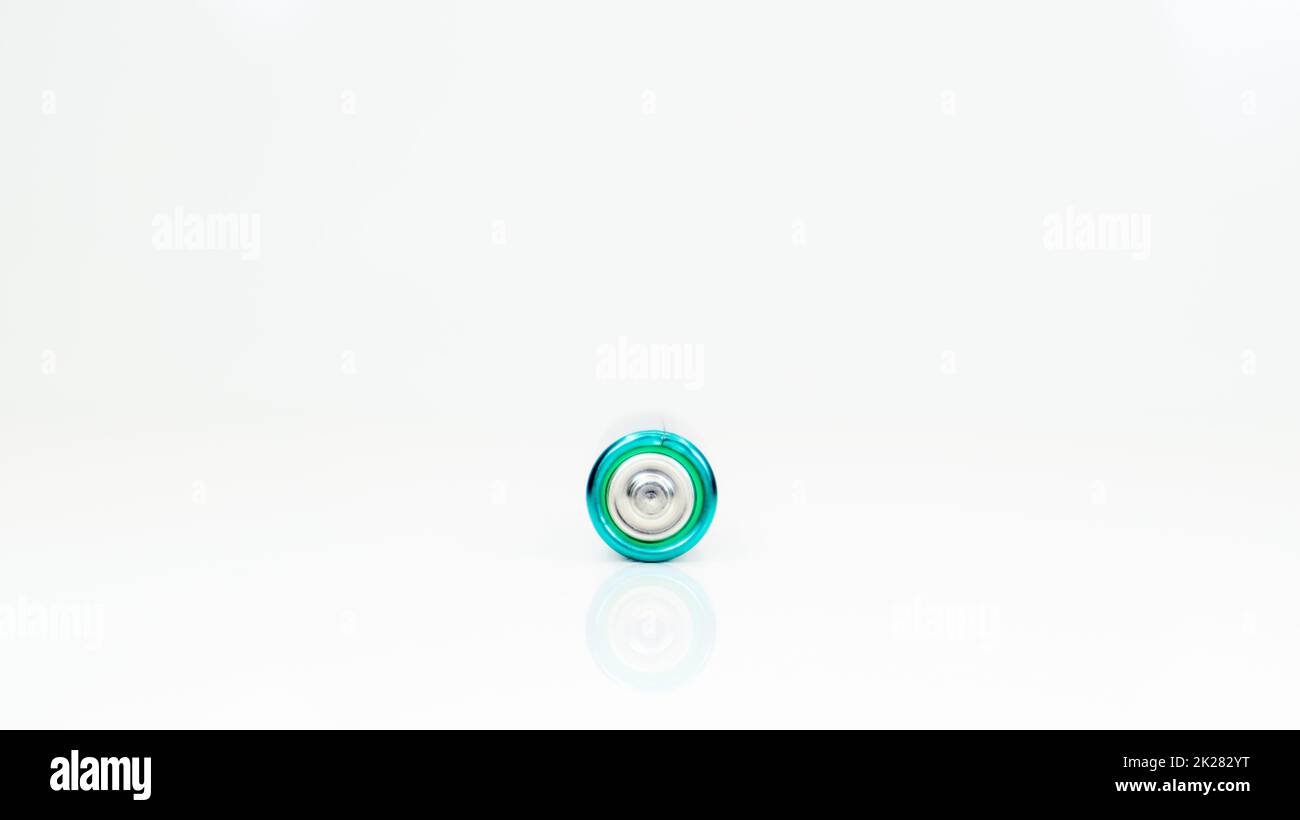 Une pile alcaline sur fond blanc avec réflexion. Concept d'approvisionnement en énergie et de recyclage. Copier l'espace. Minimalisme. L'éliminant AA est le type le plus courant de piles et d'accumulateurs galvaniques. Banque D'Images