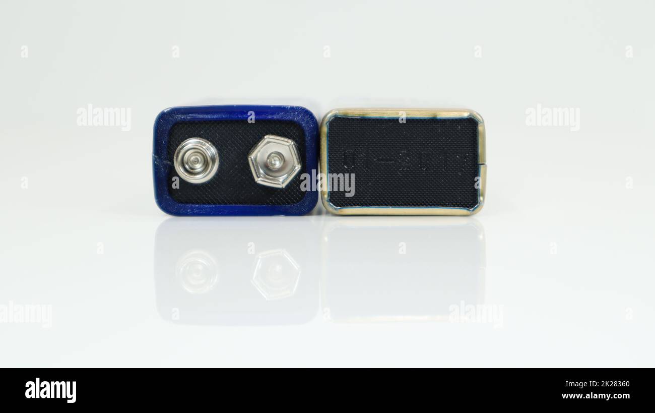 Deux bleus utilisaient PP3 piles sur un fond blanc avec réflexion. Batterie principale pour alimentations personnelles. Vue rapprochée d'un connecteur de batterie usé et rayé. Banque D'Images