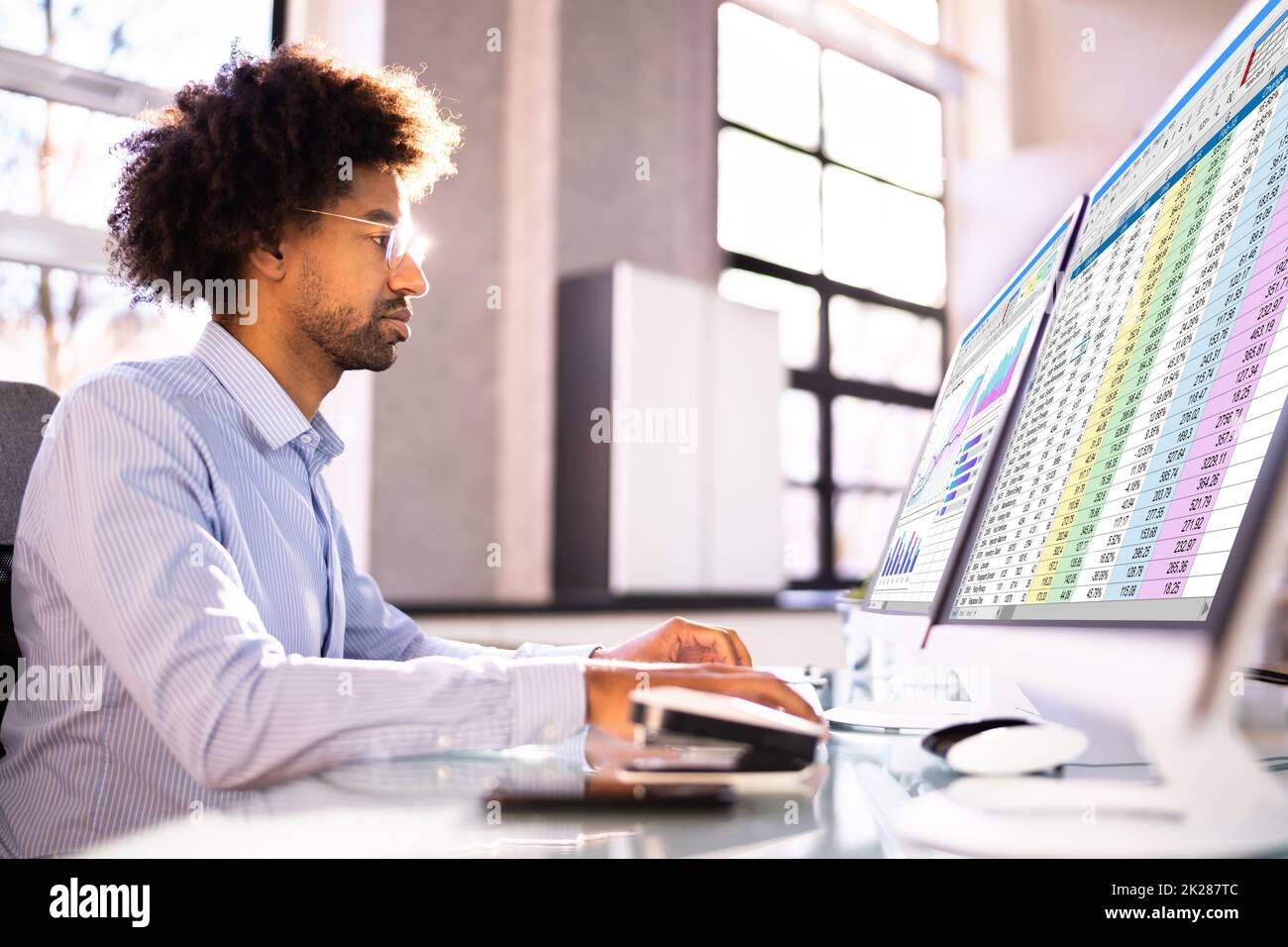 Analyste de données African Man à l'aide de la feuille de calcul Banque D'Images