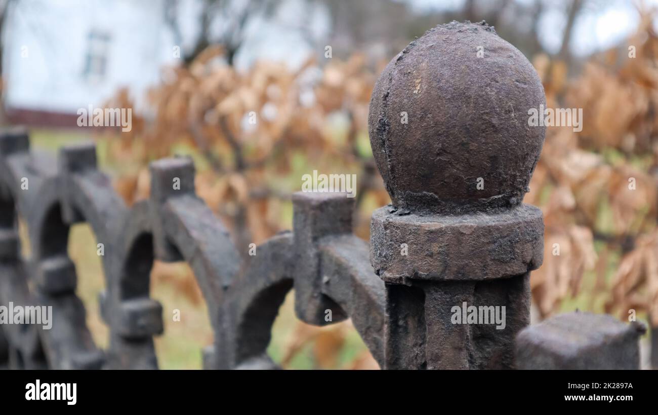 Fragment d'une clôture en fonte. Une ancienne clôture en fonte de fer forgé avec une forge artistique sur le fond d'un parc municipal d'automne. Mise au point sélective. Banque D'Images