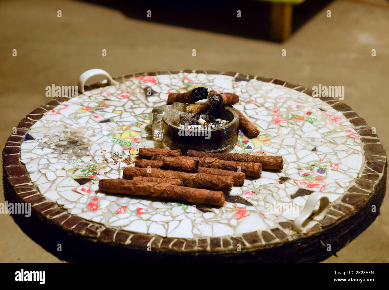 Cigare et cendrier sur la table des morceaux de poterie collés Banque D'Images