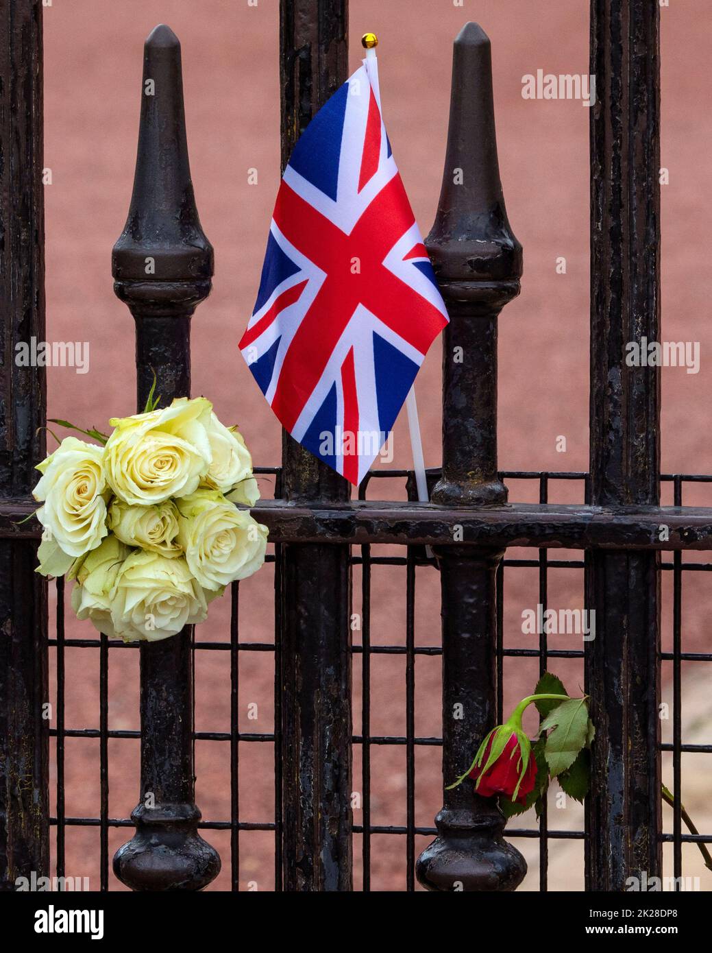 Londres, Royaume-Uni - 9 septembre 2022 : drapeau et fleurs de l'Union laissés par les adeptes de Buckingham Palace à Londres, en commémoration d'Elizabeth II, qui meurt Banque D'Images