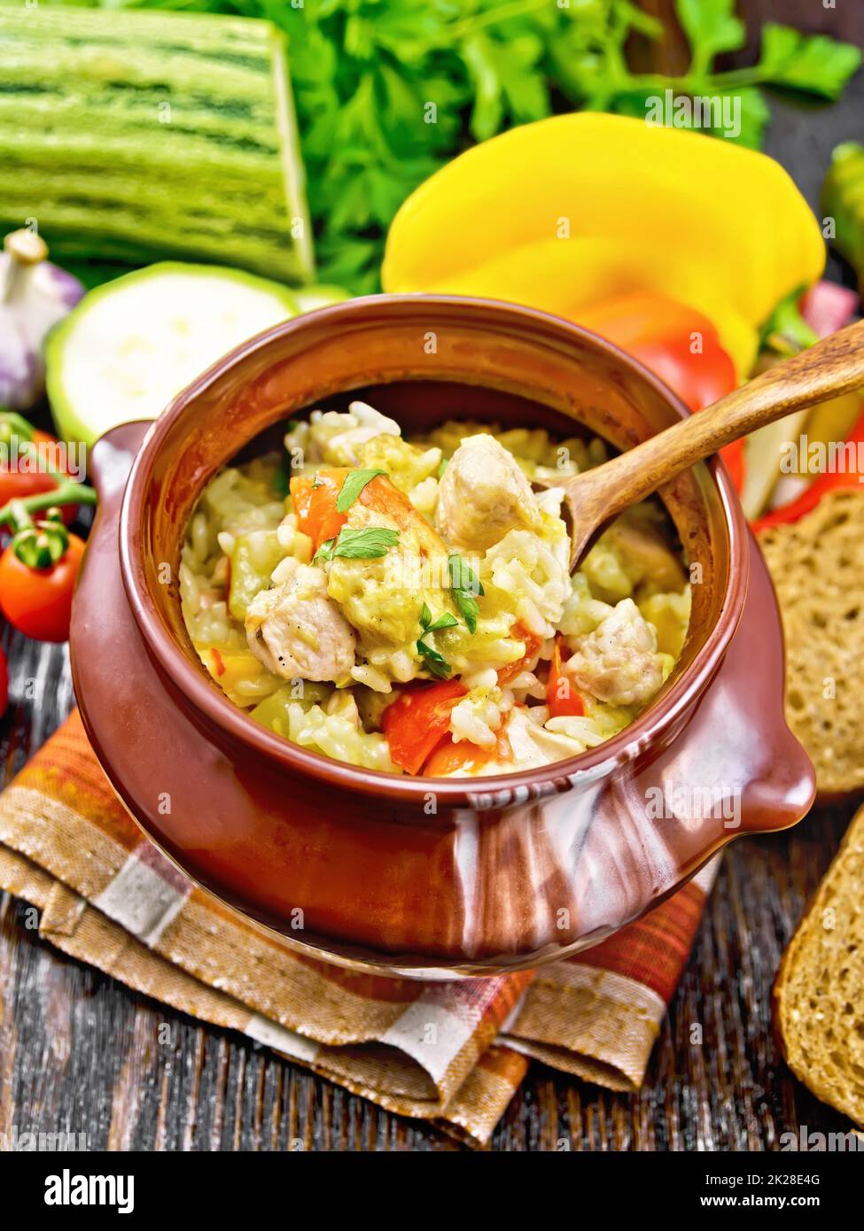 Riz avec poulet et légumes en pot sur plateau brun Banque D'Images