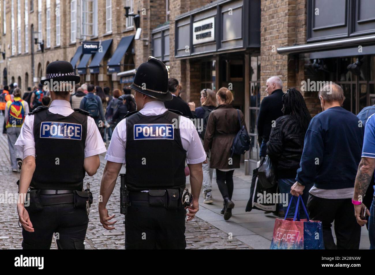 Londres, Royaume-Uni - September17th 2022: Des policiers patrouillent dans la file d'attente dans l'État de Shad Thames à Londres, Royaume-Uni. Banque D'Images