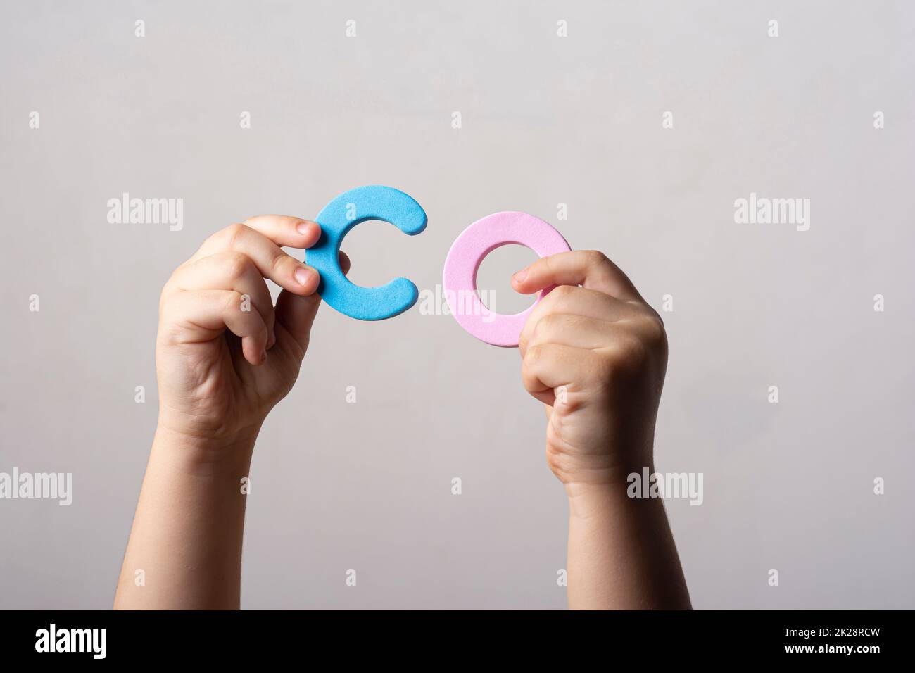 Mains tenant deux lettres spongieuses de l'alphabet bloc dans le mot CO Banque D'Images