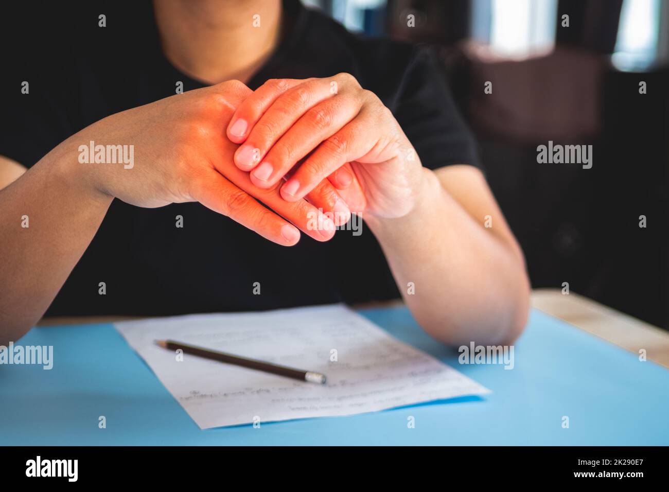 L'homme travaille à la maison. Puis ses doigts douleur. Concept de syndrome de bureau. La zone des symptômes de douleur est indiquée en rouge. Gros plan moyen. Banque D'Images