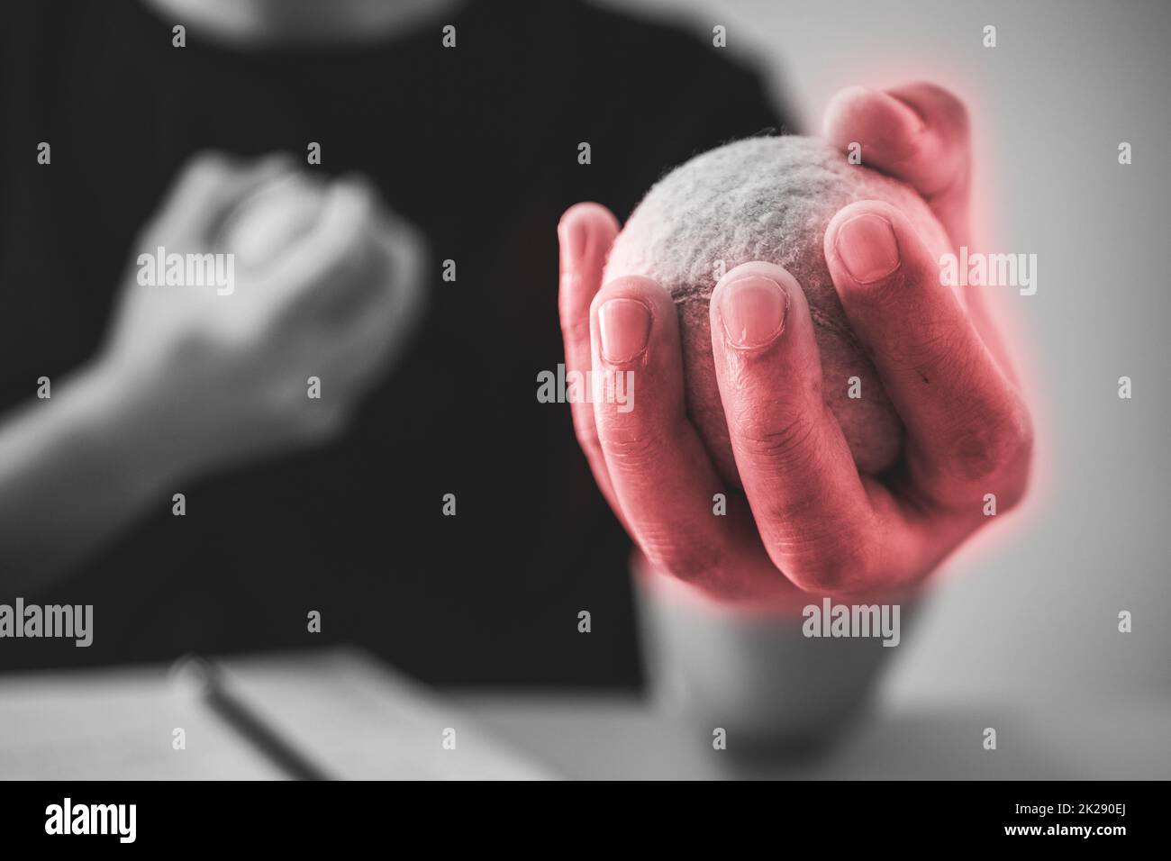 L'homme moque son doigt par des balles de tennis. Concept de syndrome de bureau. La zone des symptômes de douleur est indiquée en rouge. Gros plan extrême. Ton noir et blanc. Banque D'Images