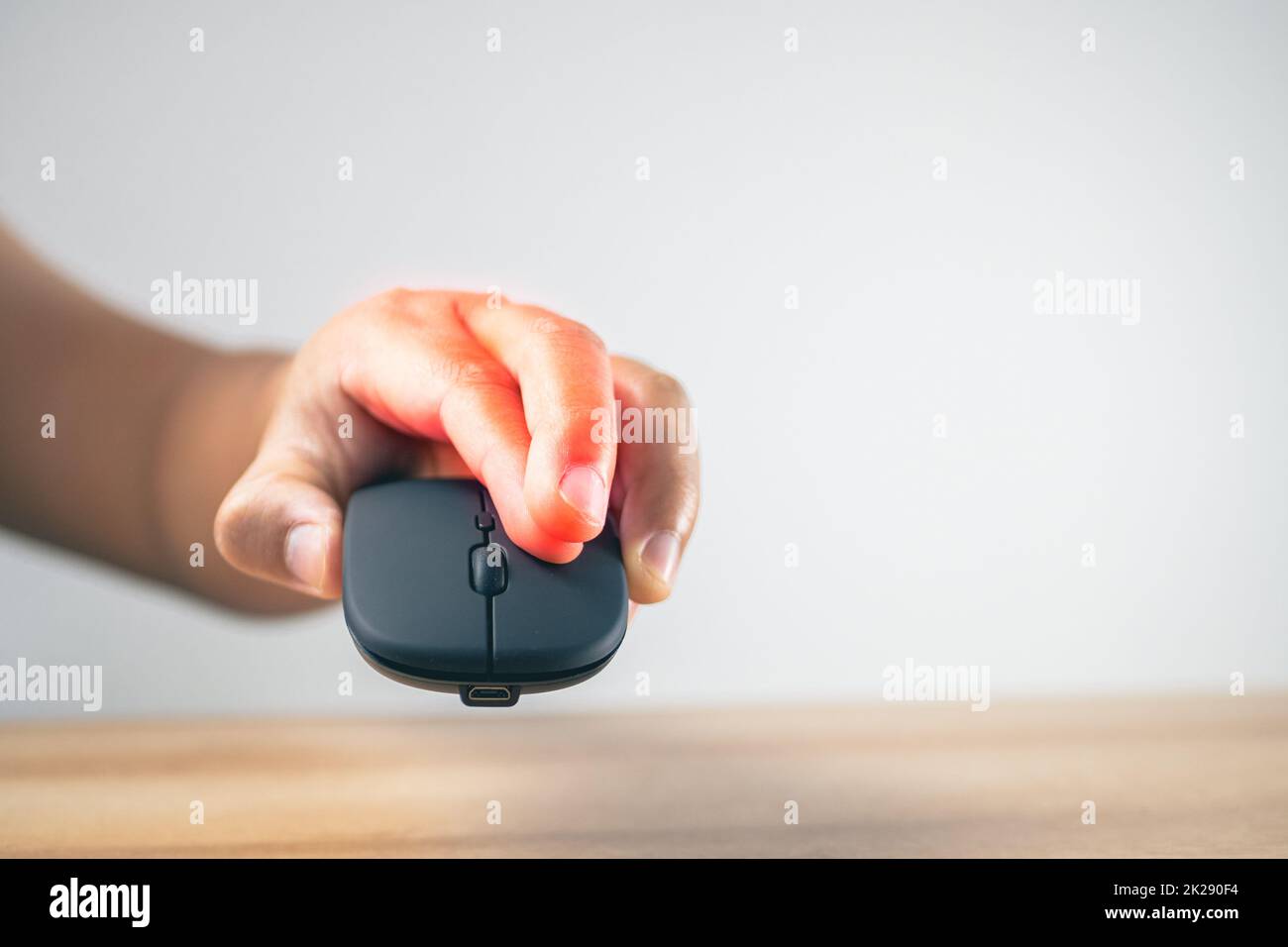 L'homme utilise une souris jusqu'à ce que ses doigts douleurs. Concept de syndrome de bureau. La zone des symptômes de douleur est indiquée en rouge. Gros plan moyen avec espace de copie. Banque D'Images