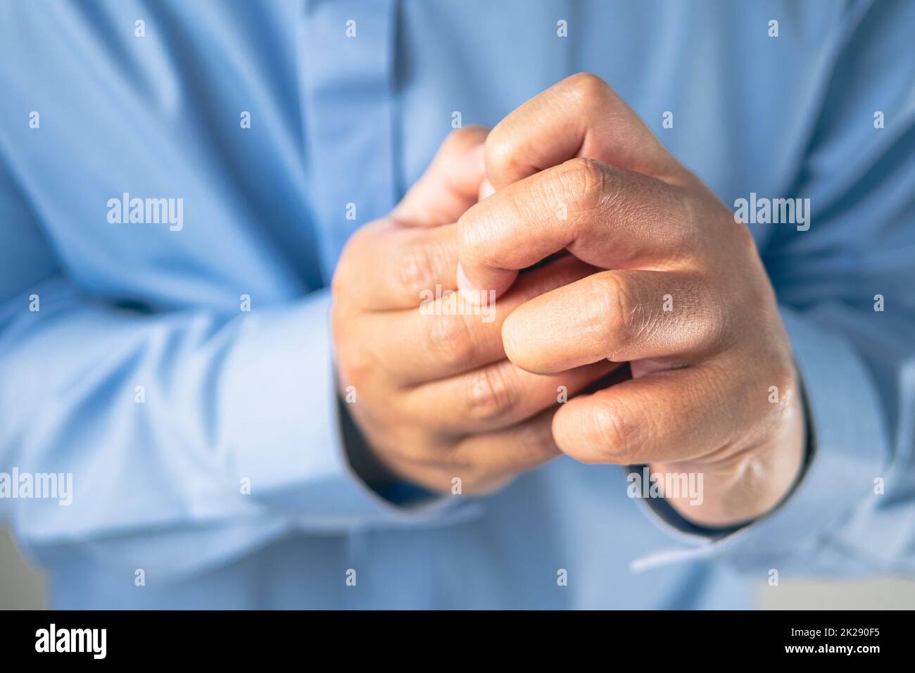 Douleur des doigts dans le concept de syndrome de bureau. Salaryman porte une chemise bleue. Gros plan moyen. Banque D'Images