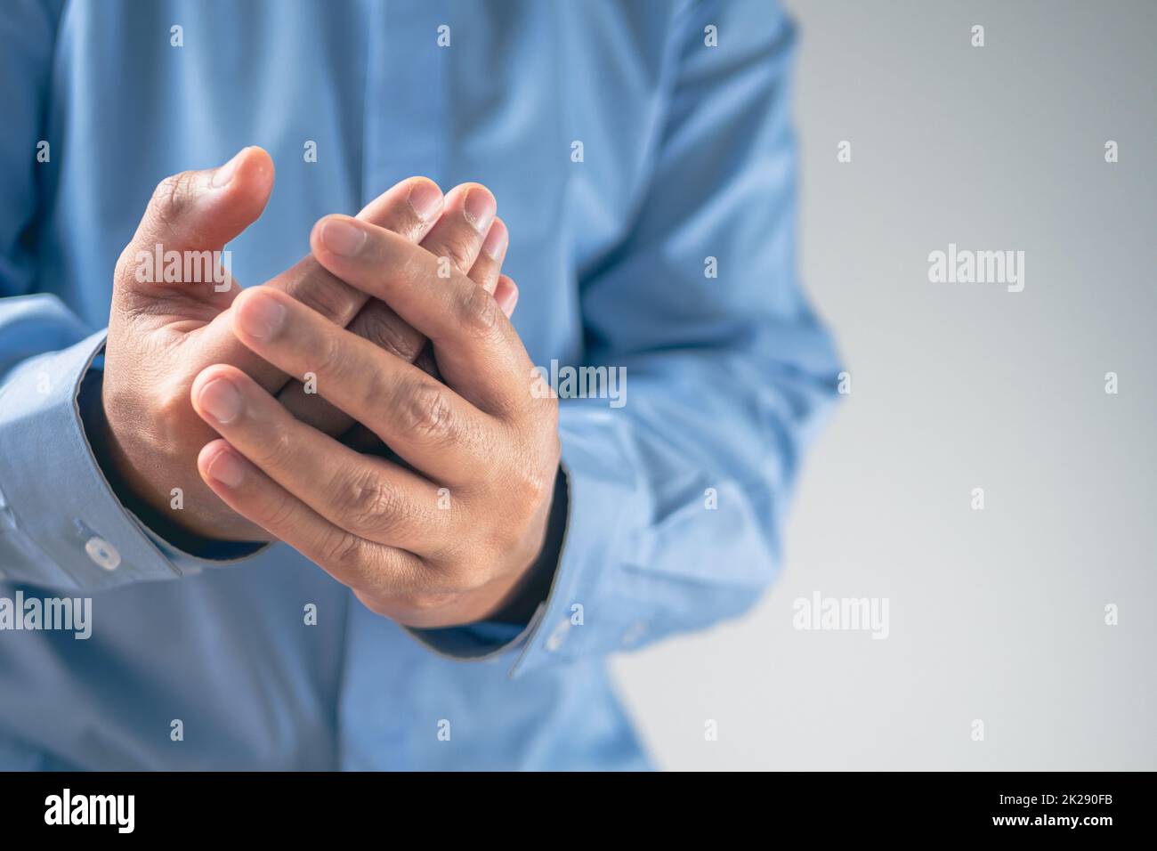 Douleur des doigts dans le concept de syndrome de bureau. Salaryman porte une chemise bleue. Gros plan moyen avec espace de copie. Banque D'Images