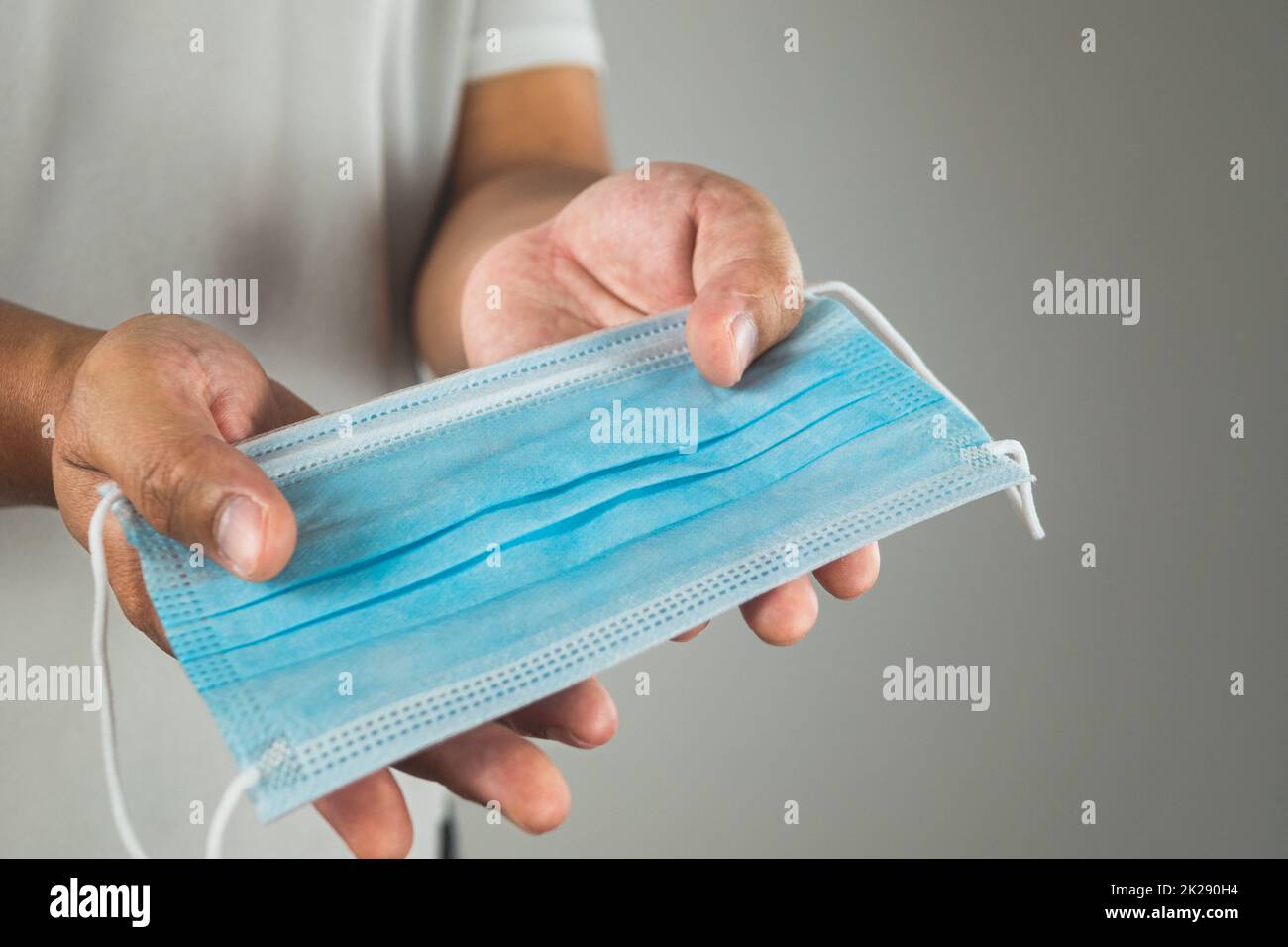 Concept médical. Donner un masque bleu à quelqu'un pour la protection de la maladie. Comme la grippe, la grippe, Covid, Dust PM2,5. Ce gros plan est focalisé sur le masque. Espace de copie pour le texte, l'image ou l'illustration. Banque D'Images