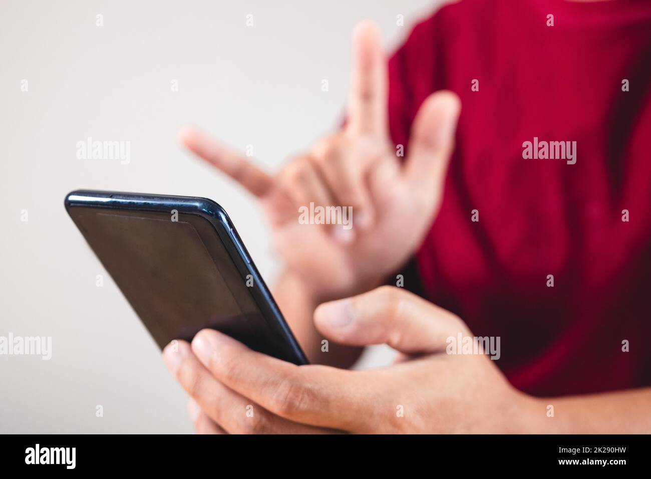 Concept de la Saint-Valentin. La personne utilise la main pour donner l'amour par le biais d'un smartphone. Cette photo a porté sur le mobile. Banque D'Images