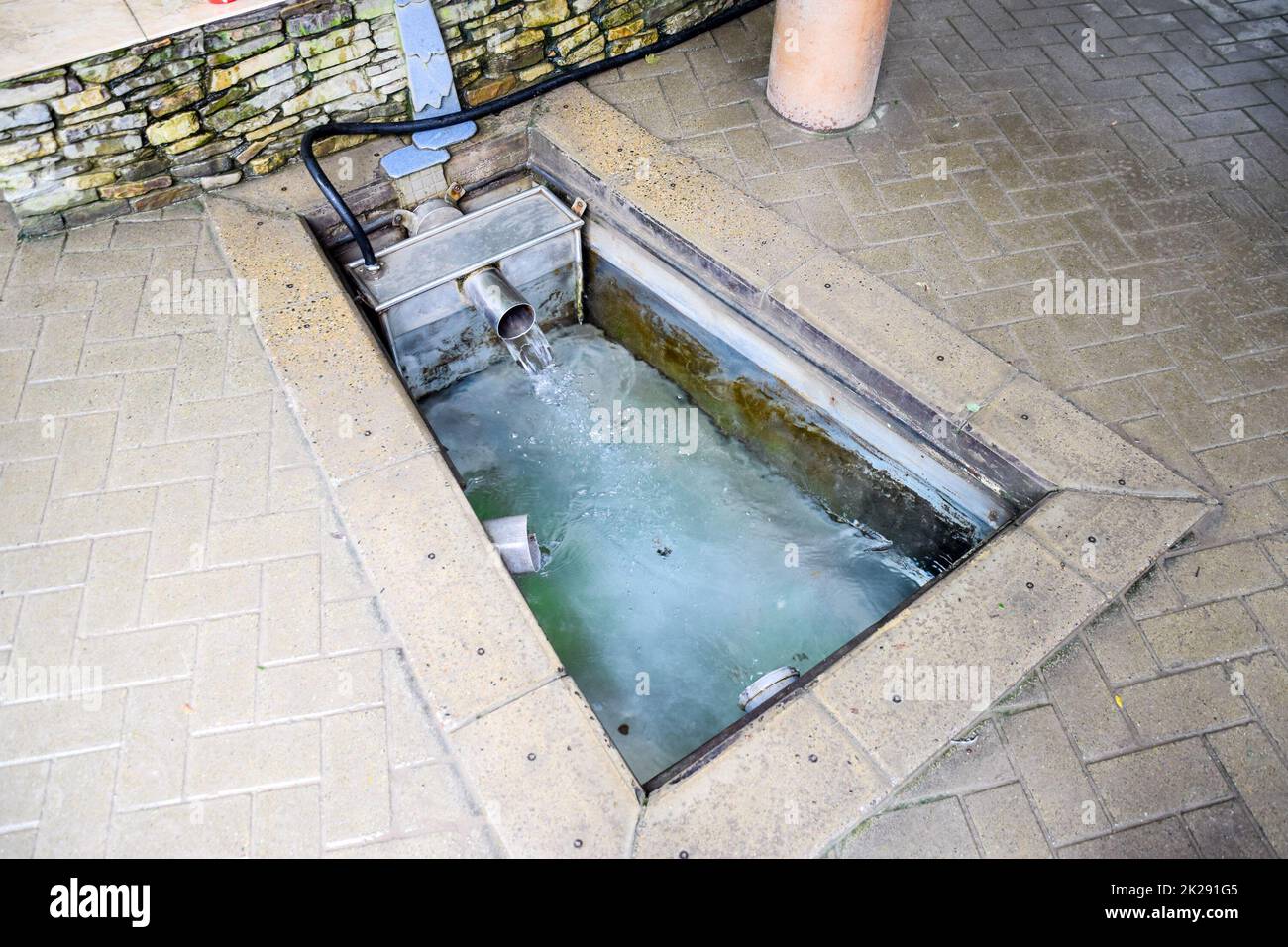 Une petite piscine avec eau de la source. Une niche dans le sol pour le recrutement d'eau d'une source Banque D'Images