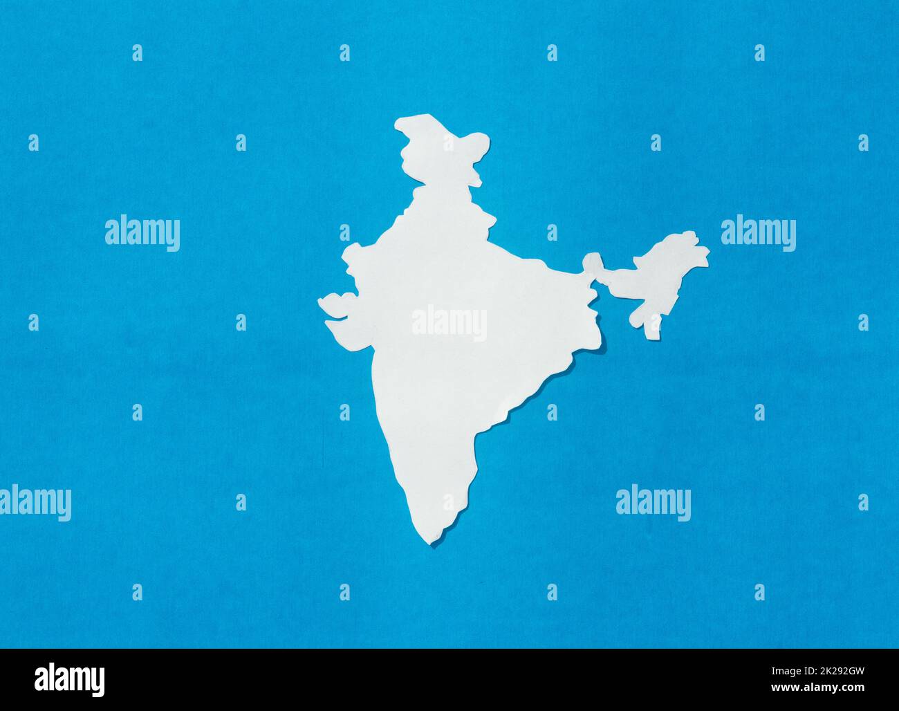 Carte de l'Inde coupée sur papier isolée sur fond bleu. Banque D'Images