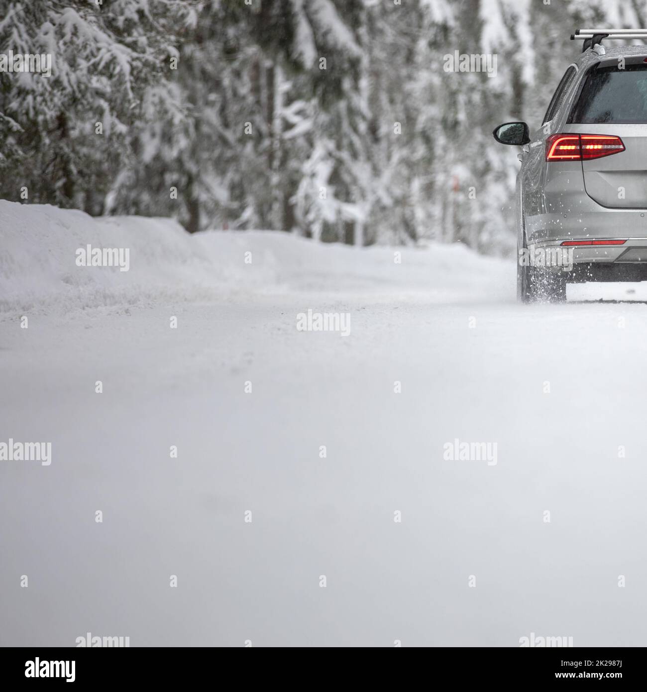 Voiture sur une route d'hiver de neige au milieu des forêts - en utilisant ses capacités de transmission à quatre roues motrices pour obtenir à travers la neige Banque D'Images